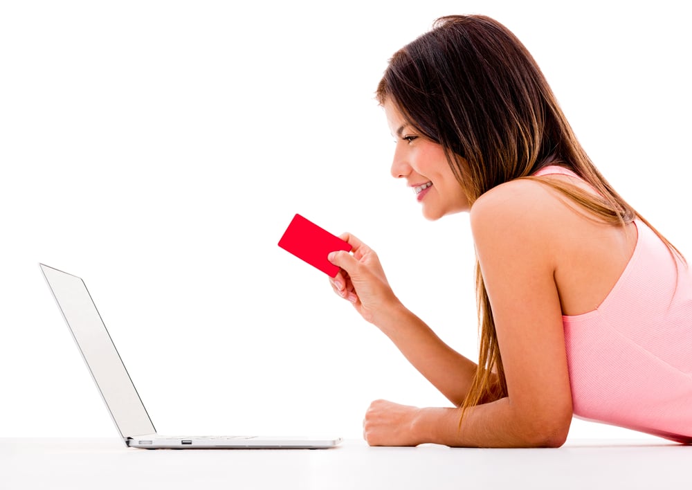 Woman online shopping with her laptop - isolated over white