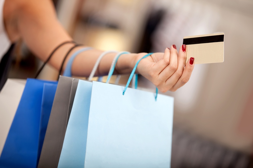 Woman shopping and paying with a debit or credit card